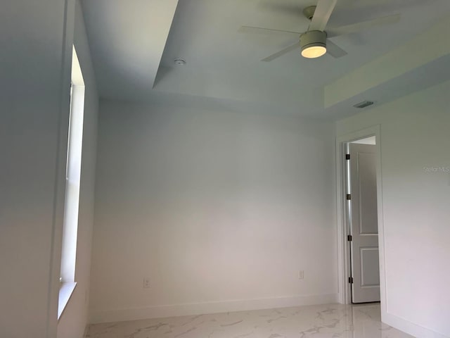 unfurnished room with a tray ceiling and ceiling fan