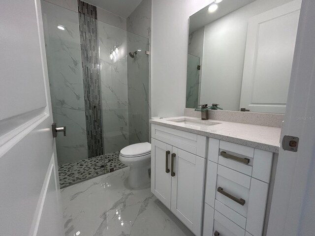 bathroom featuring vanity, toilet, marble finish floor, and a marble finish shower