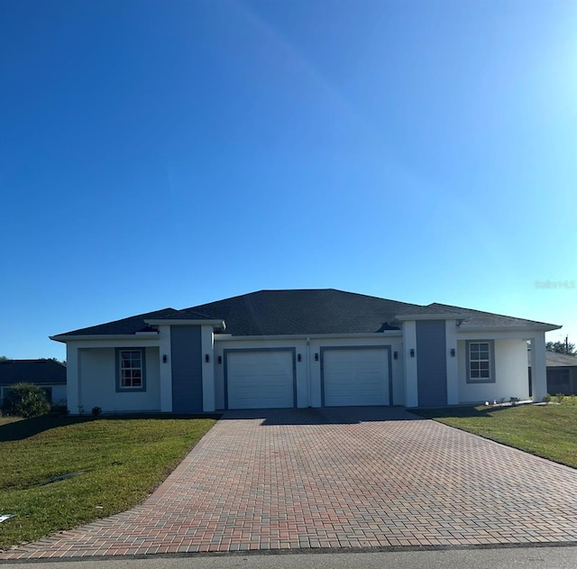 ranch-style house with decorative driveway, a front yard, an attached garage, and stucco siding