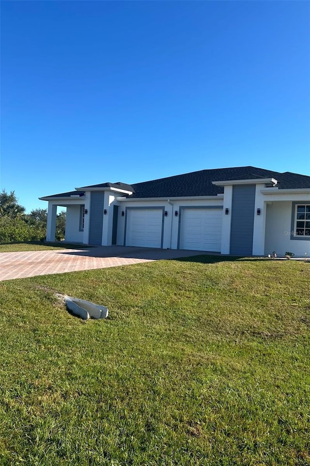 view of front of home featuring a front lawn, an attached garage, and stucco siding