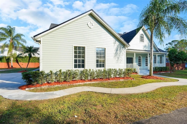 view of property exterior featuring a porch and a yard