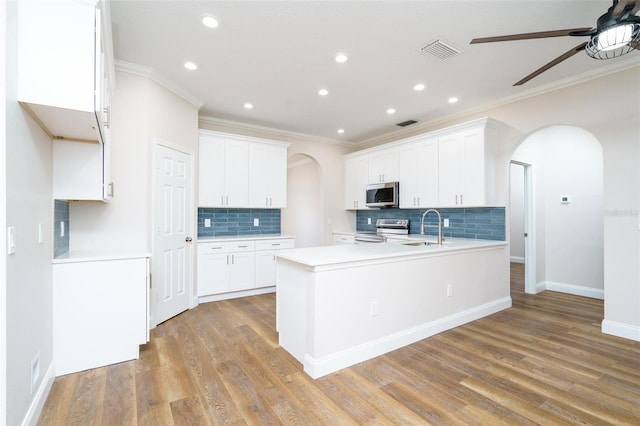 kitchen featuring white cabinetry, light wood-type flooring, and appliances with stainless steel finishes