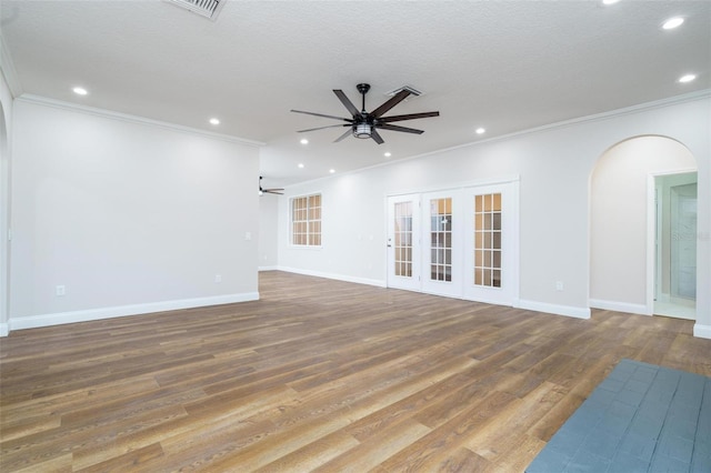 unfurnished living room featuring ceiling fan, hardwood / wood-style floors, a textured ceiling, and ornamental molding