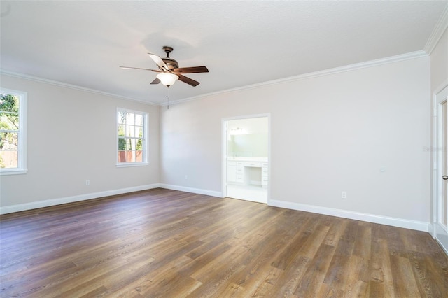 unfurnished room featuring a healthy amount of sunlight, crown molding, and dark wood-type flooring