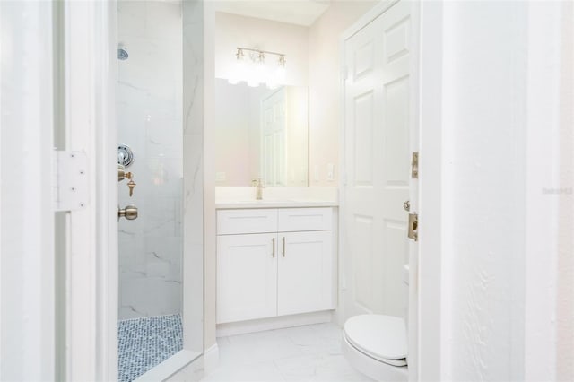 bathroom featuring vanity, toilet, and tiled shower