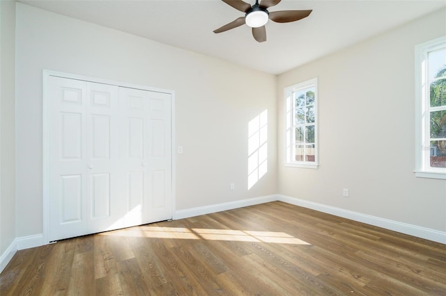 unfurnished bedroom featuring ceiling fan, wood-type flooring, and a closet