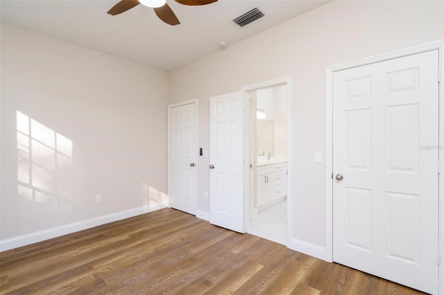 unfurnished bedroom with connected bathroom, ceiling fan, and hardwood / wood-style floors