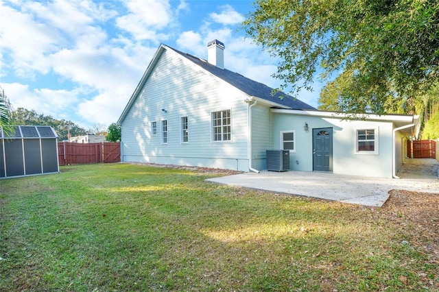 back of house with an outbuilding, a yard, and a patio