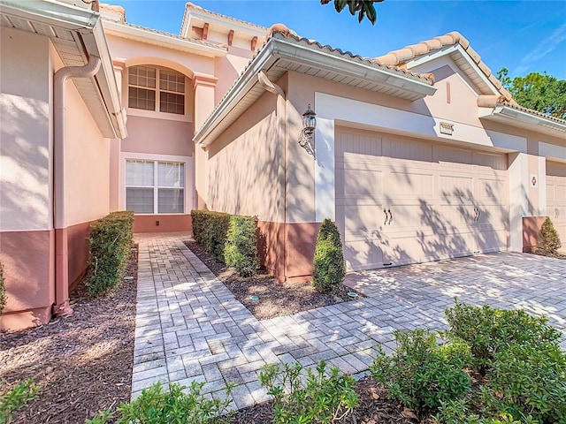 1300 Gilford Point Ln Unit 1300, Davenport, FL 33896 - view of side of home with an attached garage, decorative driveway, and stucco siding