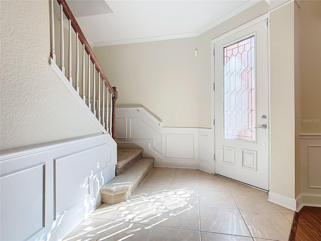 entryway featuring light tile patterned flooring and ornamental molding