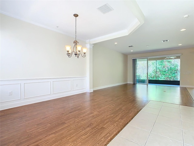 empty room with light hardwood / wood-style floors and a notable chandelier