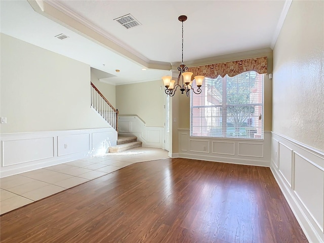 unfurnished dining area with crown molding, dark wood-type flooring, and an inviting chandelier