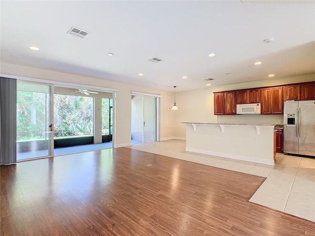 unfurnished living room with light hardwood / wood-style floors and ceiling fan