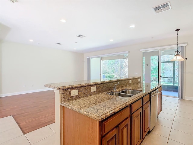 1300 Gilford Point Ln Unit 1300, Davenport, FL 33896 - kitchen featuring stainless steel dishwasher, brown cabinetry, an island with sink, light tile patterned floors, and recessed lighting