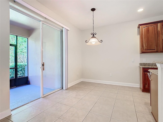 unfurnished dining area with light tile patterned flooring