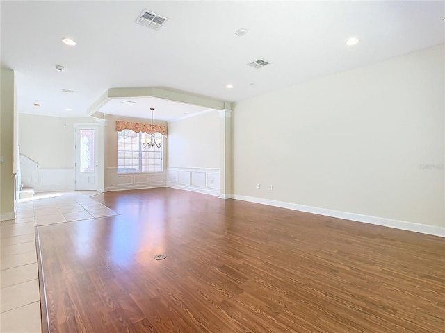 spare room featuring hardwood / wood-style floors and a notable chandelier