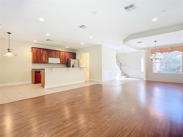 1300 Gilford Point Ln Unit 1300, Davenport, FL 33896 - unfurnished living room featuring light wood-style flooring, a chandelier, recessed lighting, and stairway