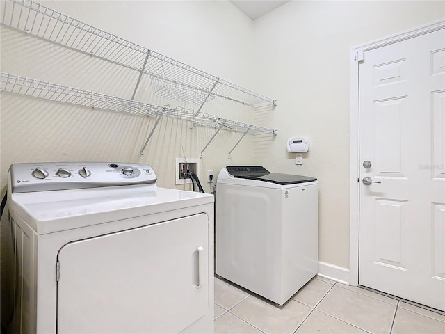 clothes washing area featuring separate washer and dryer and light tile patterned flooring