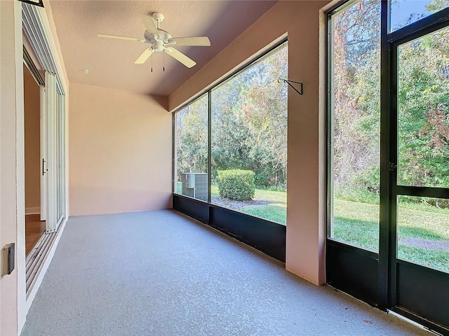 unfurnished sunroom with ceiling fan