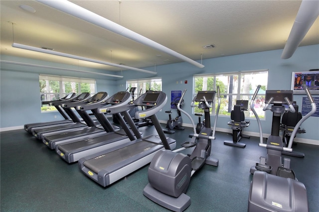 exercise room featuring a wealth of natural light and a textured ceiling