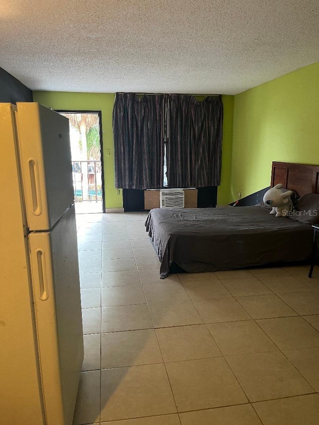 bedroom with access to exterior, cooling unit, a textured ceiling, fridge, and light tile patterned flooring