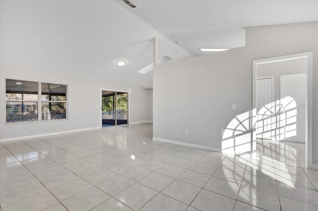 unfurnished room with lofted ceiling and light tile patterned floors