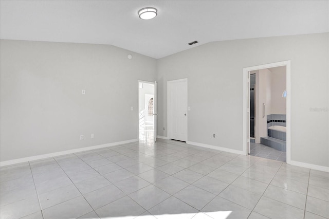 unfurnished room with lofted ceiling and light tile patterned floors