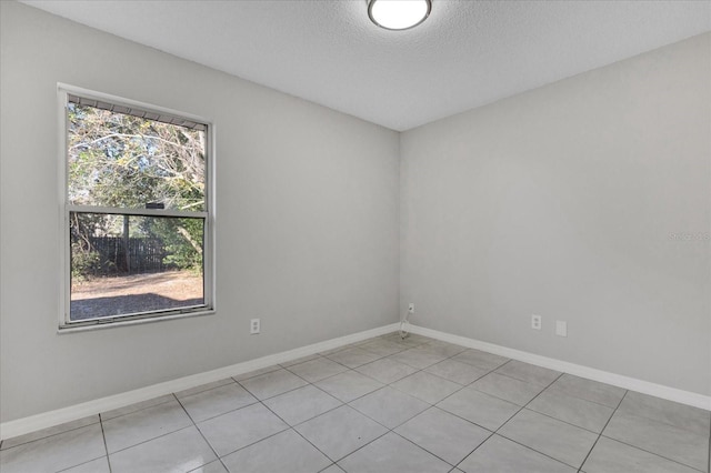 unfurnished room with light tile patterned floors and a textured ceiling