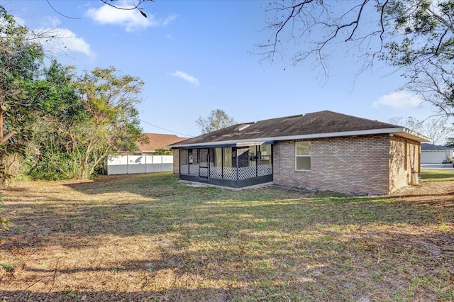 back of house featuring a yard and a sunroom