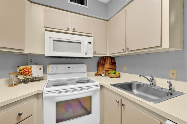 kitchen with sink, white appliances, and cream cabinetry