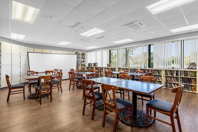 dining space featuring a paneled ceiling and hardwood / wood-style flooring