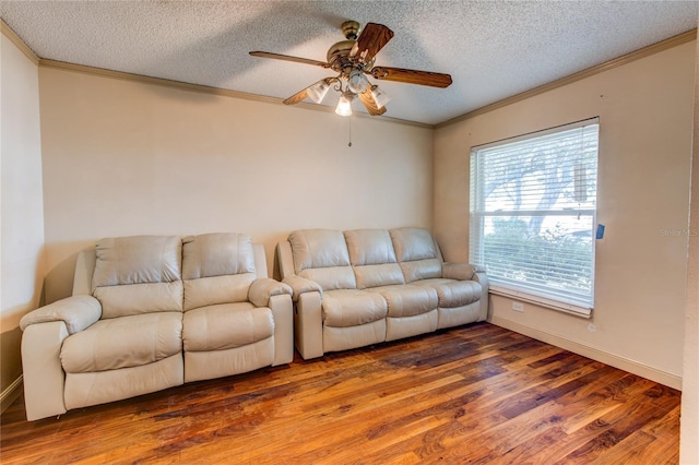 living room with hardwood / wood-style floors, ceiling fan, ornamental molding, and a textured ceiling