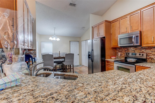 kitchen with sink, a chandelier, a textured ceiling, and appliances with stainless steel finishes