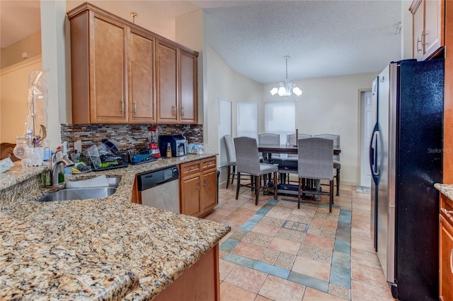 kitchen featuring dishwasher, refrigerator, sink, decorative backsplash, and a chandelier