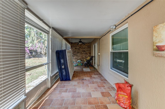 unfurnished sunroom with ceiling fan