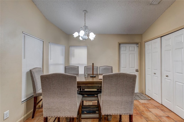 dining room with light tile patterned flooring, lofted ceiling, a textured ceiling, and a chandelier