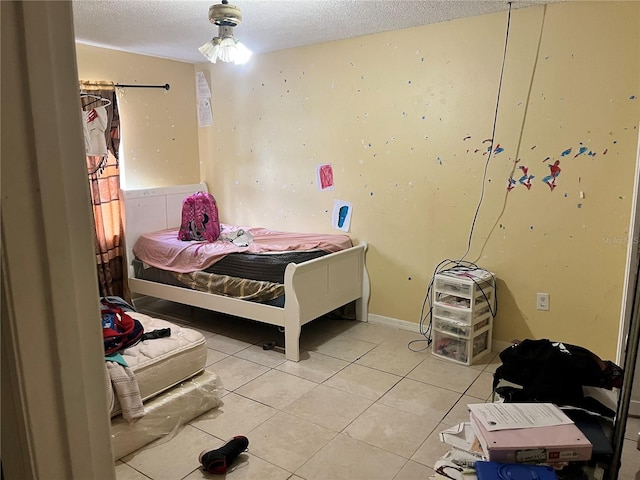 bedroom featuring tile patterned flooring and a textured ceiling