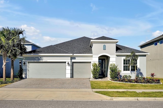 3359 Hanging Tide St, Winter Garden, FL 34787 - view of front of house with an attached garage, decorative driveway, stucco siding, and roof with shingles