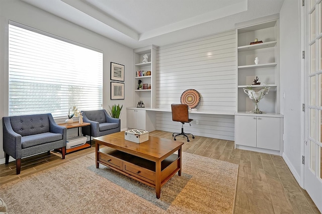3359 Hanging Tide St, Winter Garden, FL 34787 - living room with light wood-style flooring, built in shelves, a desk, and a raised ceiling