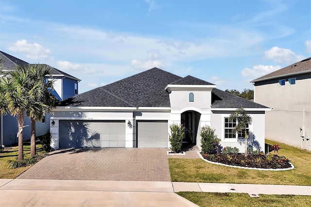 3359 Hanging Tide St, Winter Garden, FL 34787 - view of front of house featuring decorative driveway, a garage, stucco siding, and a shingled roof