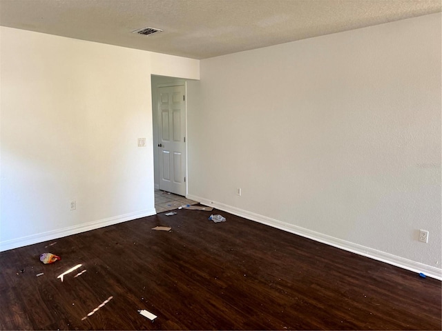 unfurnished room with hardwood / wood-style floors and a textured ceiling