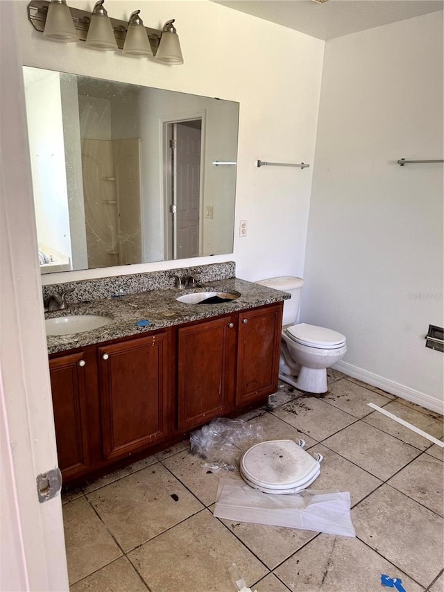 bathroom featuring tile patterned floors, vanity, and toilet