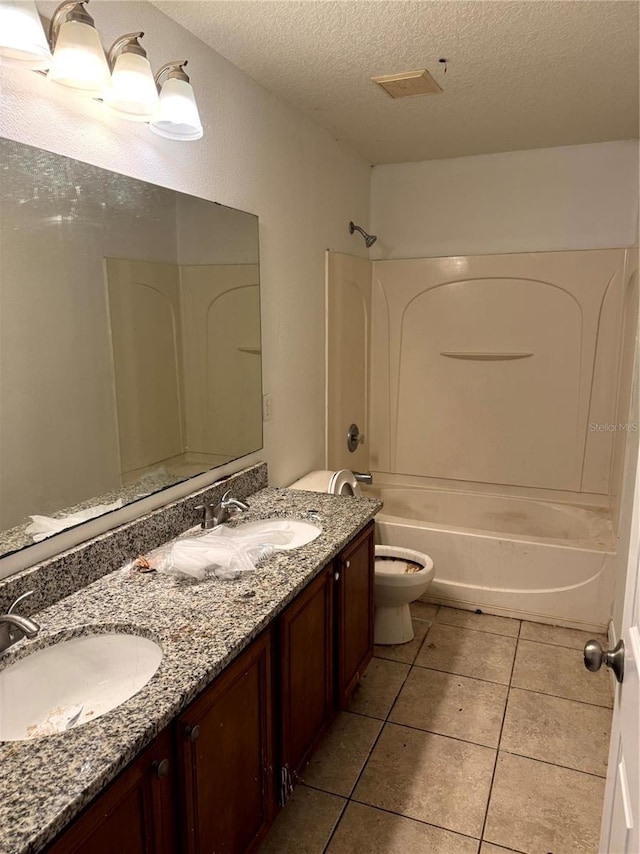 full bathroom with bathtub / shower combination, vanity, a textured ceiling, tile patterned flooring, and toilet