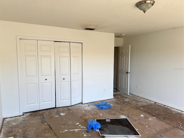 unfurnished bedroom with a textured ceiling and a closet