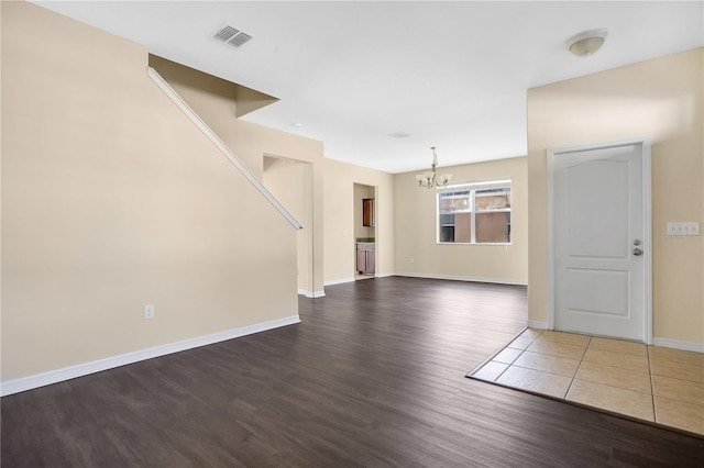 unfurnished living room featuring a chandelier and hardwood / wood-style flooring