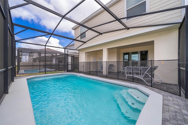 view of pool featuring glass enclosure, a patio, and a hot tub