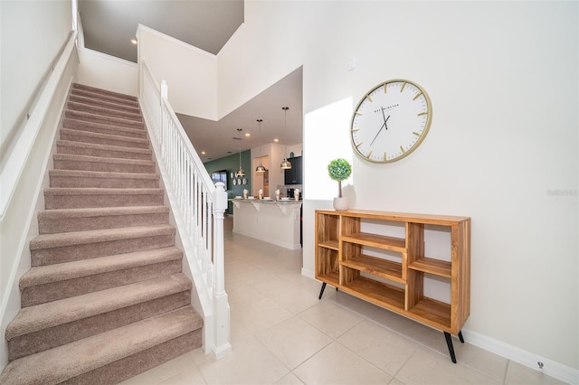 staircase with a high ceiling and tile patterned floors