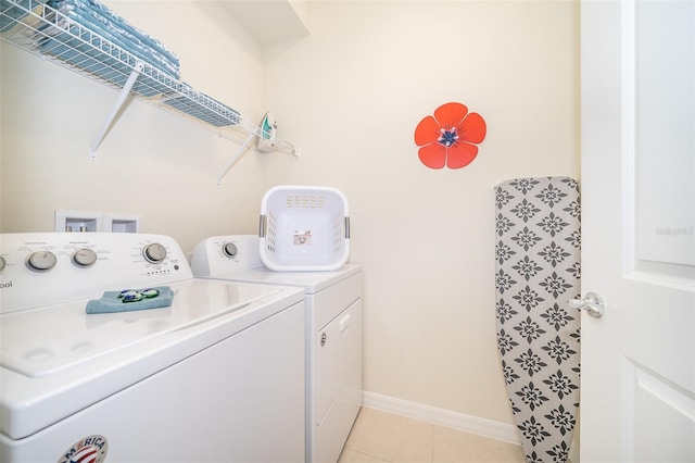 clothes washing area featuring washer and clothes dryer and light tile patterned floors