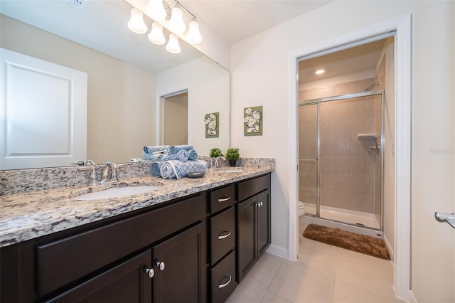 bathroom featuring tile patterned flooring, vanity, toilet, and an enclosed shower