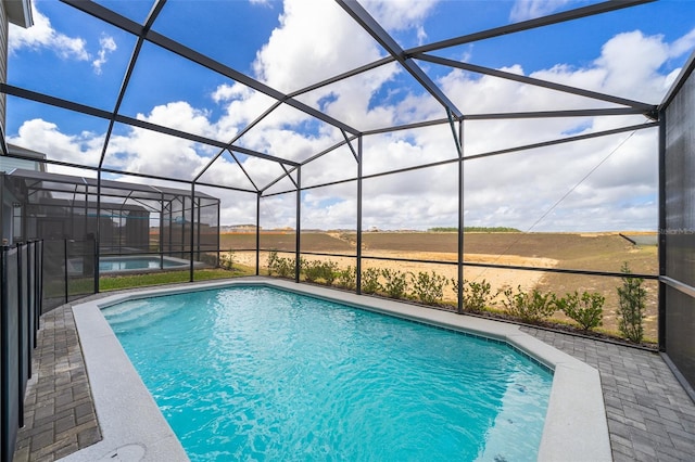 view of pool with a rural view, a lanai, and a patio